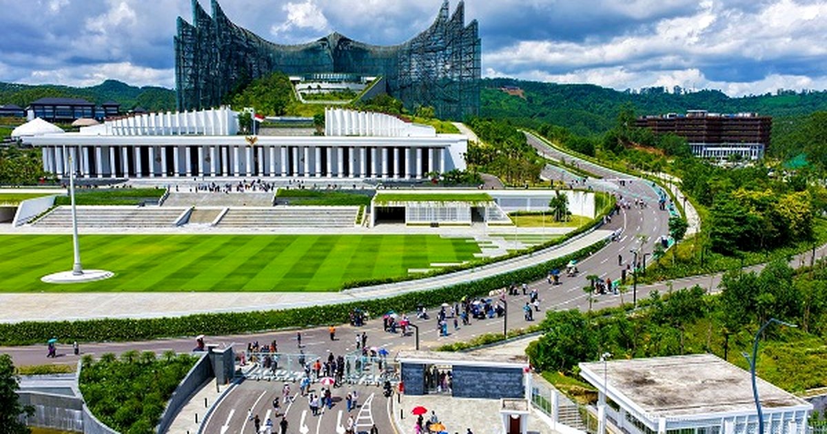 Pengunjung berjalan di kawasan KIPP IKN saat libur Iduladha 1447 Hijriah dengan latar Istana Negara Nusantara